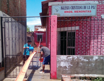 Workers remove water from a Mennonite Brethren church in Peru. — Antonio García
