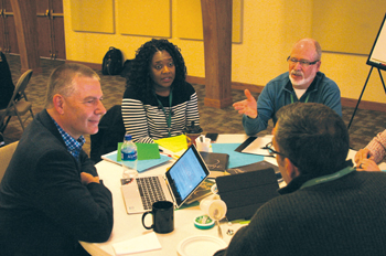 Constituency Leaders Council members, from left, Barry Bartel of Mountain States Mennonite Conference, Alicia Manning of African American Mennonite Association, Sid Burkey of Central Plains Mennonite Conference and Terry Zehr of New York Mennonite Conference (back to camera) discuss the Membership Guidelines. — Paul Schrag/MWR