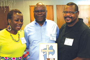 Jay Johnson, right, senior pastor of Zion Brethren in Christ Church in Abilene, Kan., received a plaque of appreciation from Zimbabwean BIC members including Don Vundla, center, and Bongi Richards July 13 in Hess­ton, Kan. — Tim Huber/MWR