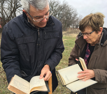 Keith and Judy Harder of Hillsboro, Kan., look at old Bibles they have collected before burying them in November in their corral. — Keith and Judy Harder