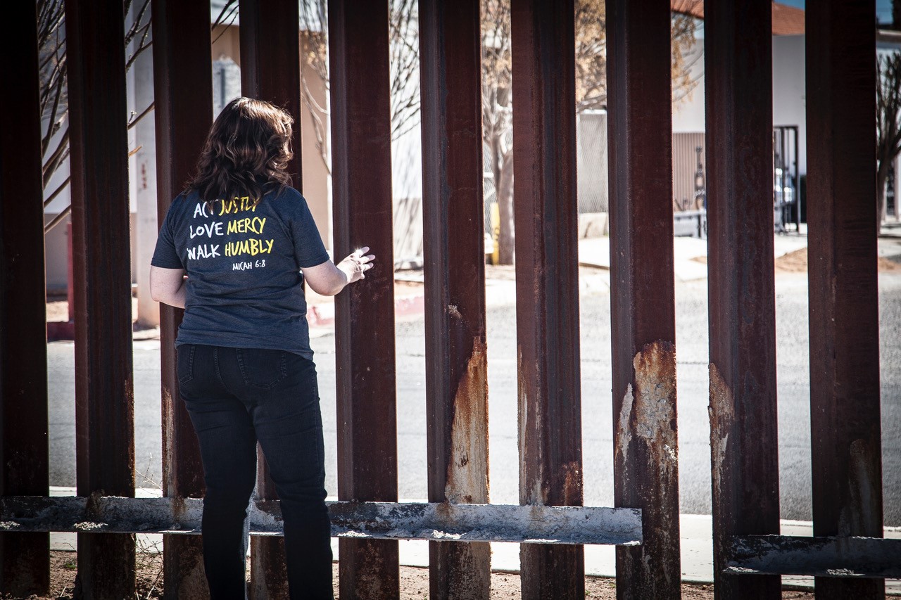 Rhonda Dueck prays at the wall in Douglas, Arizona, on the border between the U.S. and Mexico, as part of a West Coast MCC learning tour desgined to bring attention to faith-based responses to migration, militarization of the border, the effect of the border wall to communities on both sides of the border and the tragedy of migrant deaths. (Photo/James Bergen)