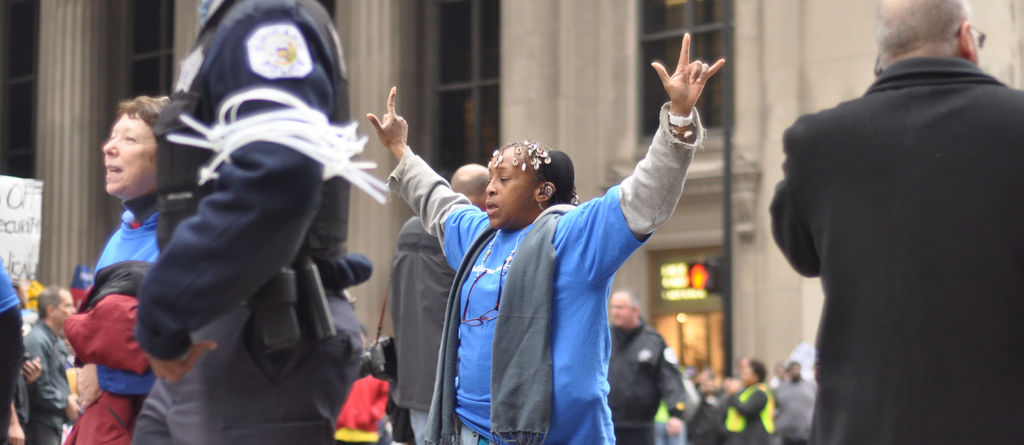 Woman signing "I love you" after being arrested by police for blocking an intersection as part of nonviolent direct action in Chicago, November 7, 2011